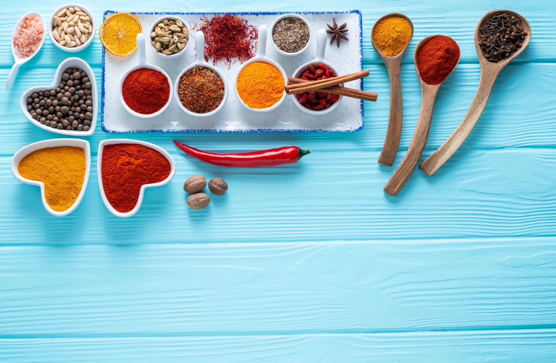 Spices herbs and condiments on light blue wood table