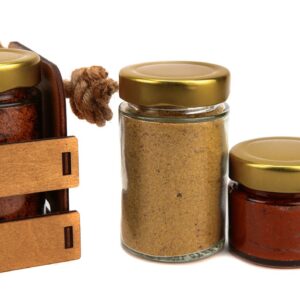 A set of spices in glass jars, packed in a wooden box with a rope handle