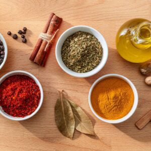 Bowls filled with spices and herbs shot from above on wood background